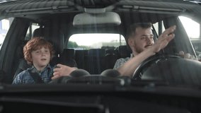 Happy father and his son sitting in the car and waving by hands. Slow motion - Powered by Shutterstock - Get 15% off with code: PIKWIZARD15