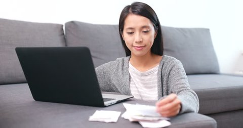 Woman counting expense on laptop computer