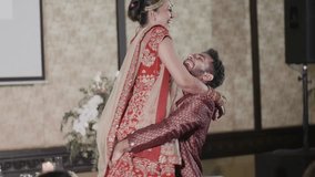 Cheerful Newlywed Couple Dance At Wedding Reception - Indian Groom Carrying His Bride While Turning Around. slow motion shot - Powered by Shutterstock - Get 15% off with code: PIKWIZARD15
