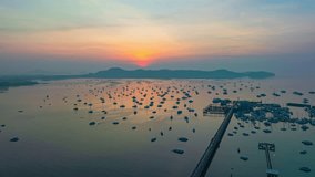 Aerial hyper lapse view amazing cloud in yellow sky at sunrise above Chalong marina. scenery The beauty of the sky was mesmerizing in the morning.colorful cloud over Chalong pier Phuket Thailand.