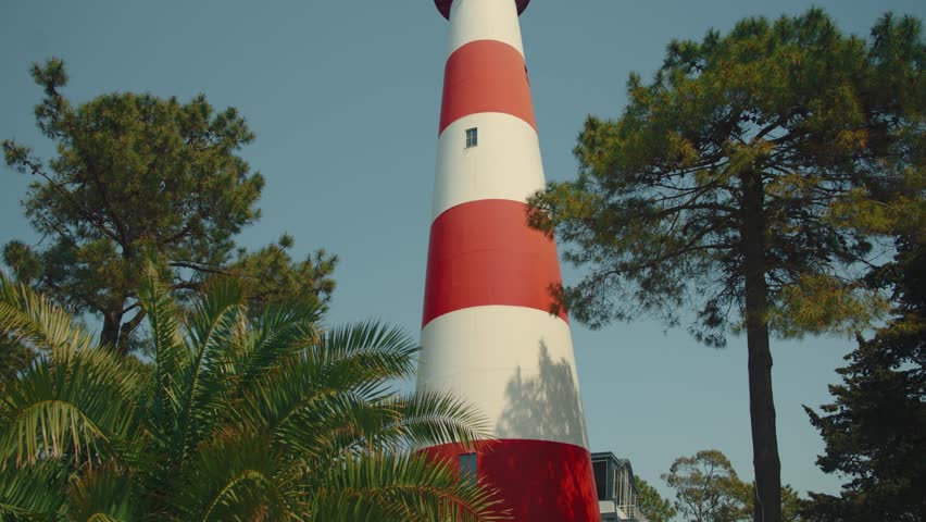 Cinematic shot of Poti Lighthouse at Dusk, Lighthouse Located on a Rocky Coastline Against the Black sea .