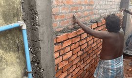 Workers building side wall known as compound wall