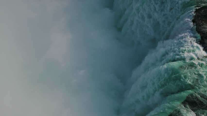 Niagara Falls on both the American and Canadian sides. Powerful waterfall of crystal clear waters. Majestic and misty rapids of the 56 km long Niagara River. Boat under the waterfalls with tourists.
