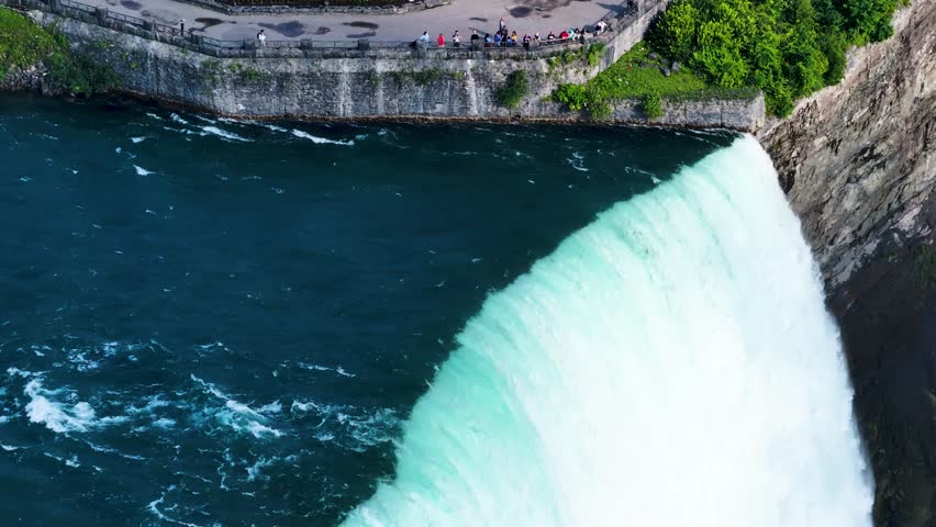 Niagara Falls on both the American and Canadian sides. Powerful waterfall of crystal clear waters. Majestic and misty rapids of the 56 km long Niagara River. Boat under the waterfalls with tourists.

