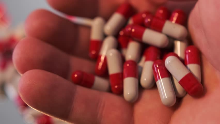 Medicine pills tablets in hand close up. Dose of drugs for course of treatment in human palm. Medication, healthcare and treatment concept