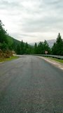 First-person footage of driving, serpentine mountain road. Video shows driving, serpentine path through scenic area. Captures experience of driving, serpentine route in mountains