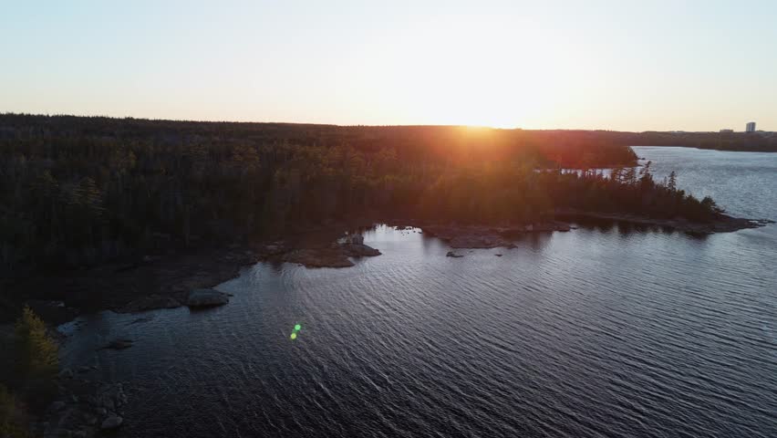 Cinematic drone view of a wild forest and lake. Picturesque spring landscape with Long Lake and colorful spring forest at sunset, Canada early spring, beautiful nature of Nova Scotia city of Halifax