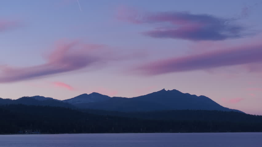 A view of Lake Tahoe at dusk, with mountains in the background, showcasing the natural beauty of the landscape as the sun sets. 4K footage.