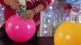Man using glue to make DIY decorative balls from balloons for party decorations