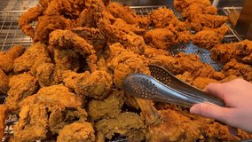 Light battered deep fried chicken variety mix pieces pile flaky meat on white background pick drop tong . High quality 4k footage