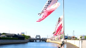 Carp streamers on Handa Canal swaying in the blue sky and wind in May.In Handa City, carp streamers are put up along the Handa Canal as the May holidays approach.