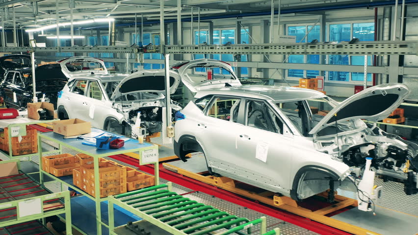 Unfinished automobiles put in a row in the factory facility. Car assembly line, automobile industry concept.