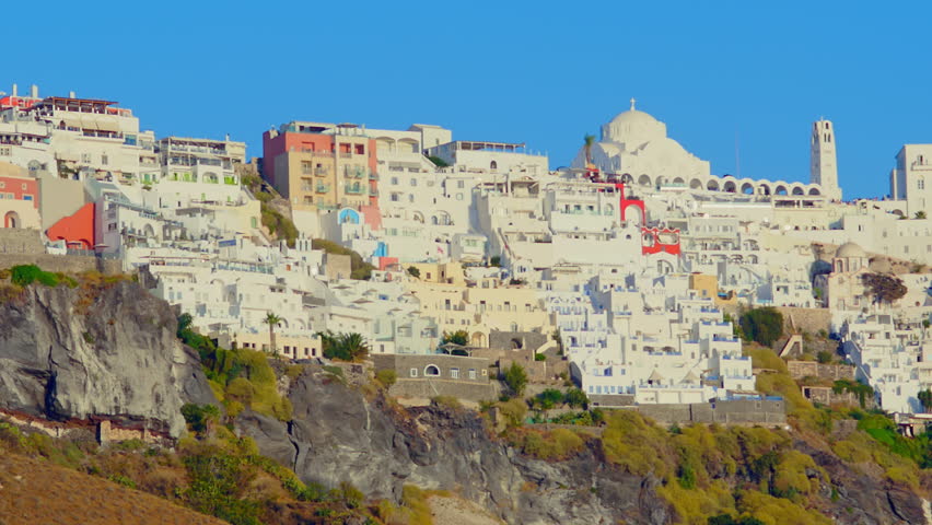 View from the deck of a cruise ship of Fira built on top of a rock that drops sheer into the sea. Santorini-Greece