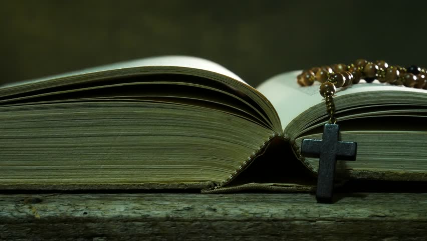Open Bible with Rosary on the Used Table. Sliding.