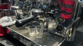 Pouring a stream of coffee from the machine into a cup.