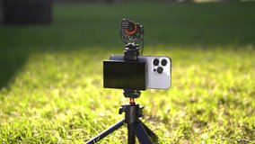 Equipment for shooting video on a smartphone. Microphone, tripod, screen smartphone on outdoor