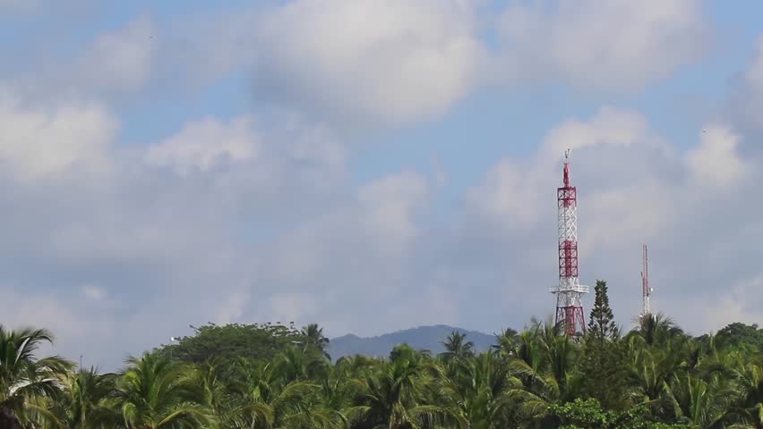 Red white 5G tower with blue sky background radiation kills us in Zicatela Puerto Escondido Oaxaca Mexico.