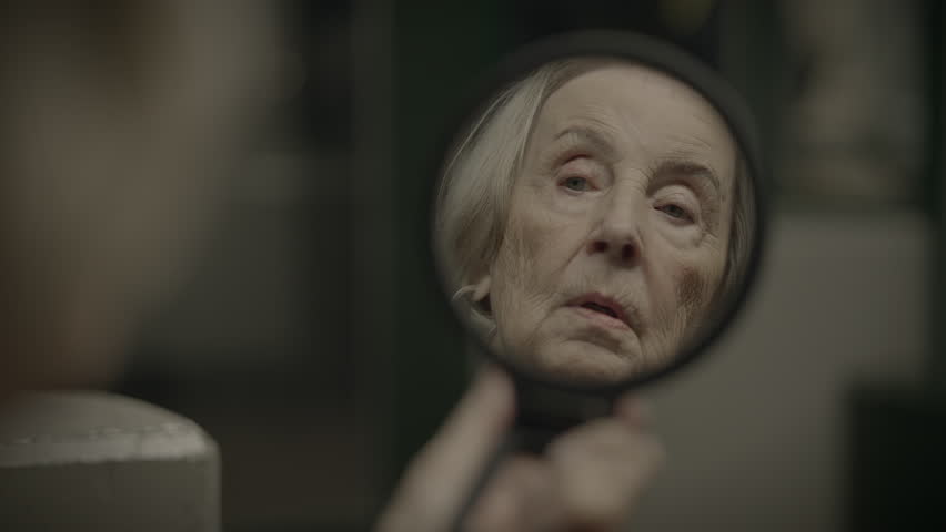 Old lady looking at the mirror
