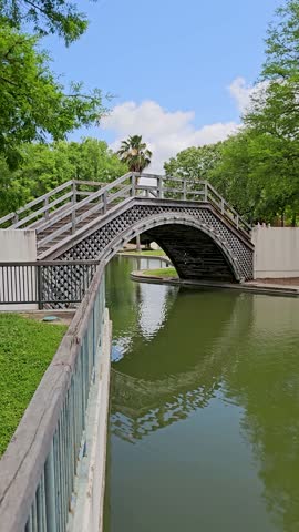 panning footage of a gorgeous spring landscape at Louis Armstrong Park with lush green trees and grass, a lake, blue sky and clouds in New Orleans Louisiana USA