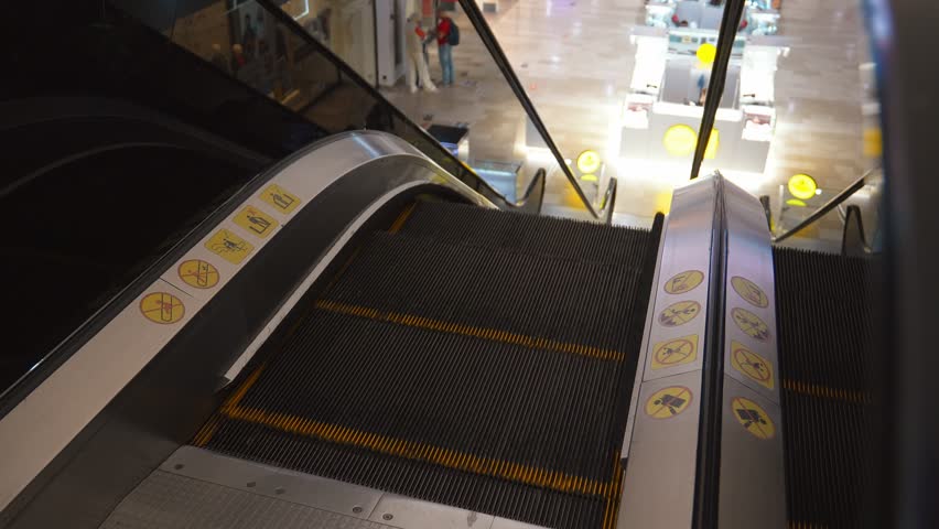 Close-up of escalator in shopping mall. Moving Down Stairs. Electric Escalator. Close to escalators. Close Up Floor Platform.
