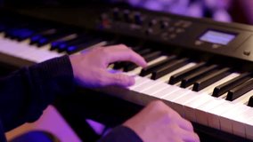 Woman pianist plays gentle classical music on a beautiful grand piano with one hand close-up in slow motion. Piano keys close up in dark