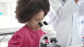 African American schoolgirl pupil student looking through microscope during science practical class in school laboratory. asia children scientists learning biology chemistry lesson . Elementary School - Powered by Shutterstock - Get 15% off with code: PIKWIZARD15