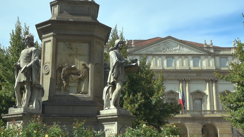 Closeup of Leonardo Da Vinci statue in Milan, Scala building architecture facade by day