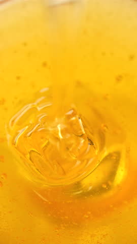 Thick organic honey pouring in bowl