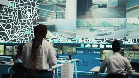 Team leader gives order tracking details to her employees in control center, people working together to guide delivery trucks on less busy routes. Using surveillance footage and gps. Camera B. - Powered by Shutterstock - Get 15% off with code: PIKWIZARD15