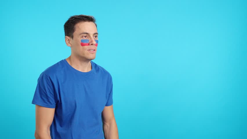 Happy man with haitian flag painted on face looking away