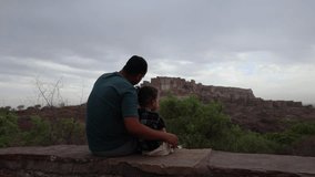 father with infant son watching historical fort at cloudy day video is taken at mehrangarh jodhpur rajasthan india. - Powered by Shutterstock - Get 15% off with code: PIKWIZARD15