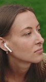 Vertical video, Close-up of a beautiful woman listening to music on wireless headphones