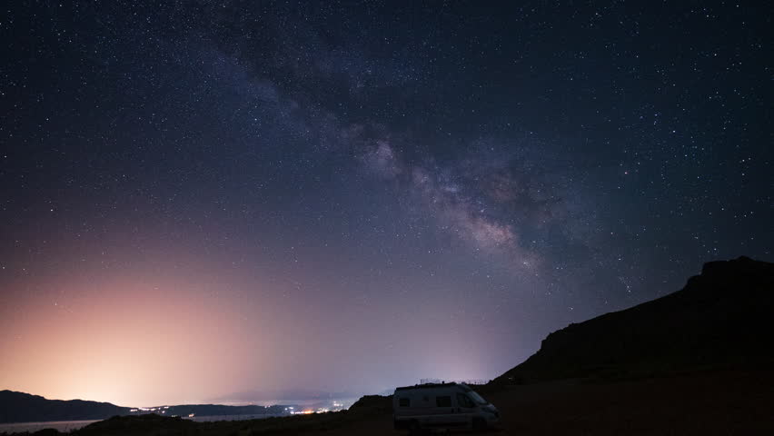 Starry sky with milky way passing over camper van