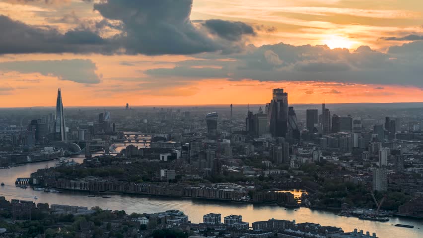 Panoramic sunset to night time lapse view view behind the urban skyline of London, England, with River Thames and City buildings