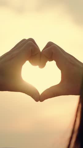 Healthy heart concept. Girl molded love heart from her palms. Light of summer spring sun is in my hands. Travel, relax, nature. Heart symbol, love, healthy. Happy girl making heart shape with fingers.