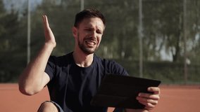 Caucasian man on sports field looks intensely at tablet and becomes emotionally upset. Sports fan is angry about team and his bad bet on bookmaker app. Portrait of bettor with negative emotions. - Powered by Shutterstock - Get 15% off with code: PIKWIZARD15