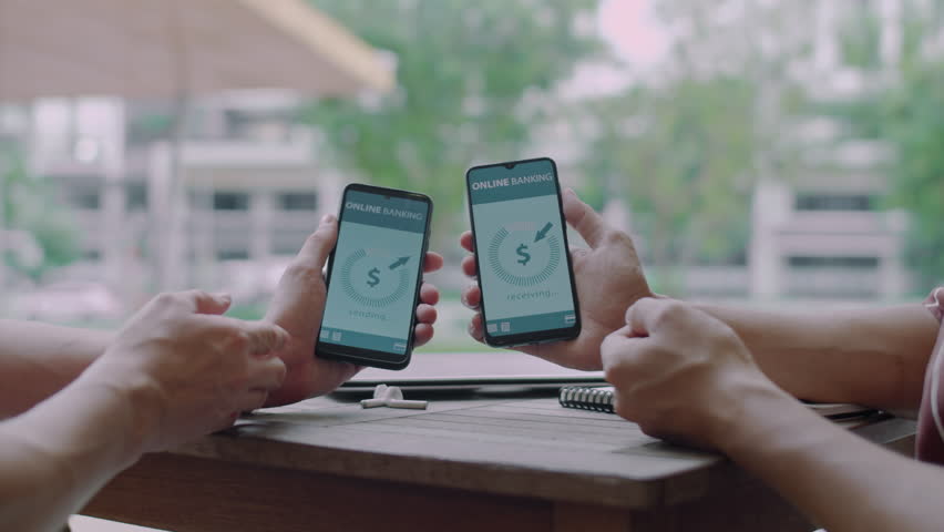 Close up of hands of crypto investors transferring currency on bank accounts using apps on smartphones