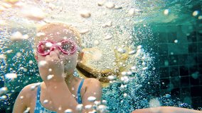 Cute girl swim in the swimming pool. Happy smiling girl diving and swimming. Girl diving underwater in pool.  - Powered by Shutterstock - Get 15% off with code: PIKWIZARD15