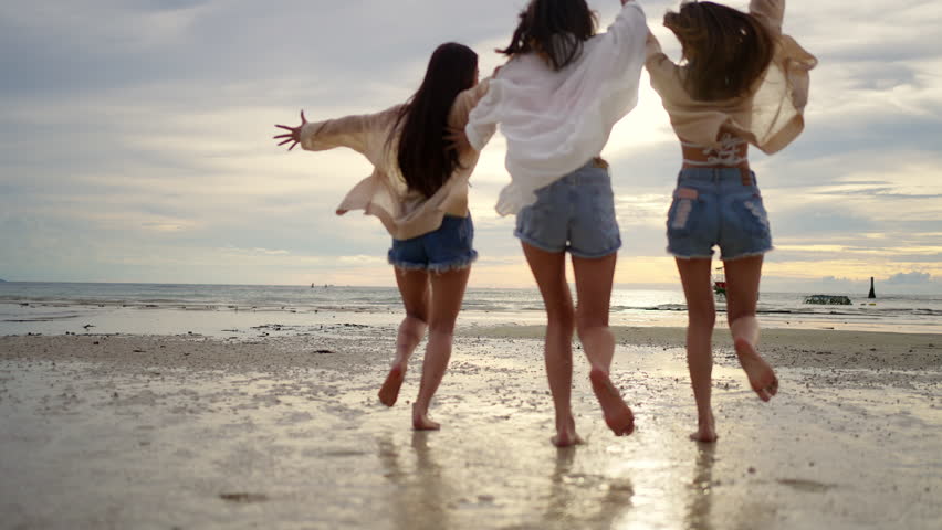 4K Group of Young Asian woman enjoy and fun outdoor lifestyle travel nature ocean on summer beach holiday vacation. Attractive girl friends walking and playing together at the sea on tropical island.