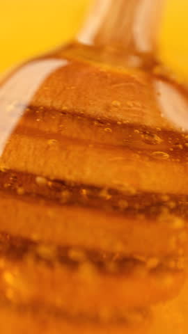 Taking a spoon out of honey. Thick organic honey dripping from a wooden honey spoon