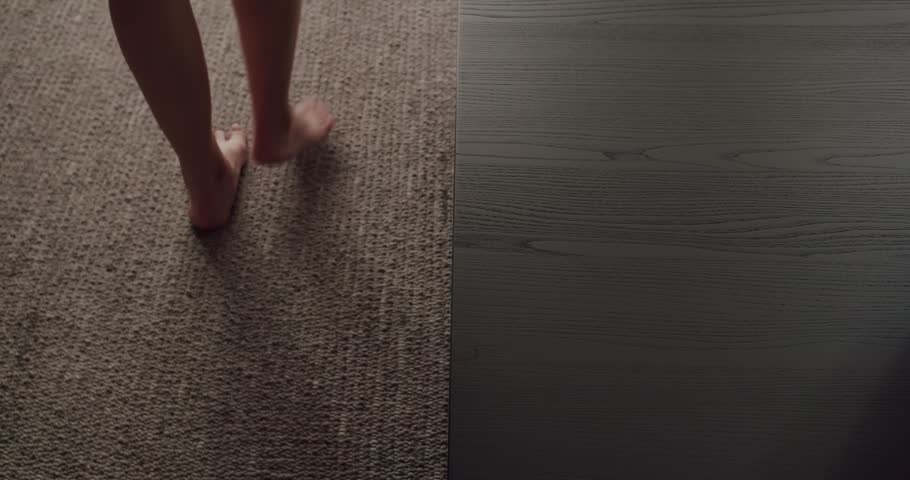 A simplistic yet evocative image capturing the bare foot of a girl walking on carpet transitioning to a smooth wood surface. A Minimalist Image of Texture Contrast