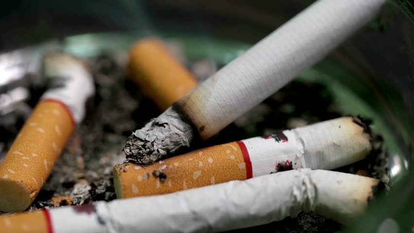 Extinguish a cigarette in an ashtray full of butt cigar stop smoking concept unhealthy lifestyle 4k