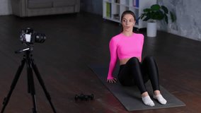 Beautiful sporty woman doing exercise on the floor at home, while pumping abs and abdominal muscles on fitness mat. Home fitness, workout concept. Real time video.