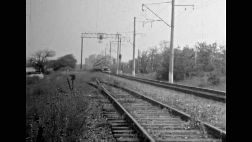 Train moving by railway tracks, black white film, close up. Train wagon move with speed. Travel by rail through countryside on summer nature background. Vintage old archive. Retro 1980s transportation