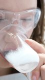 young beautiful teenage girl with a plastic glass getting teeth in dentistry drinking water with foam in transparent glasses brushing teeth oral hygiene slow motion video. close up face