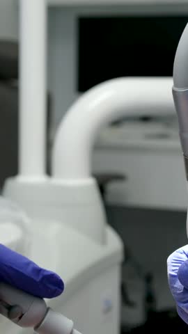 professional teeth cleaning in a dental clinic, removing stones and plaque, young specialists working with a woman, cleaning a saliva ejector, sucking out saliva, applying paint to the teeth Royalty-Free Stock Footage #3496331341