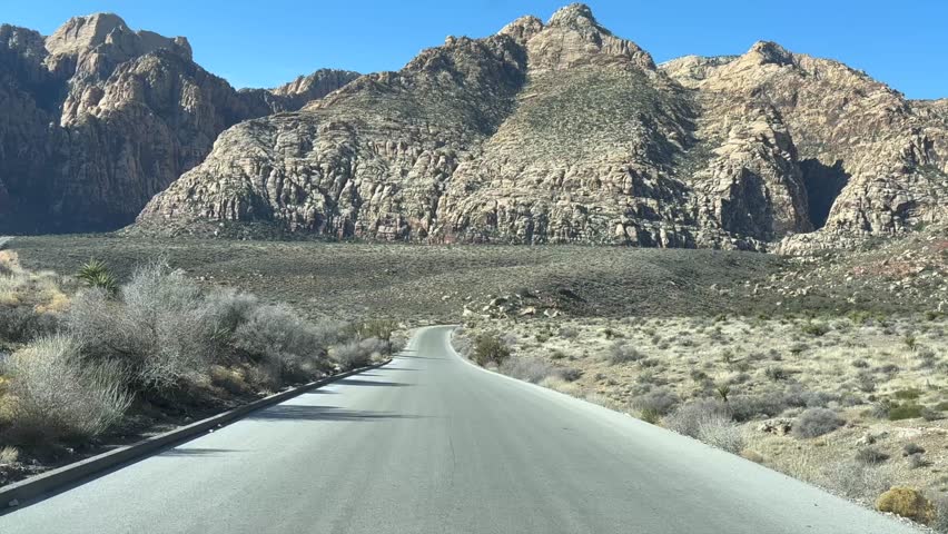 Driving the beautiful Red Rock Canyon Park Road with stunning mountain views. Driver