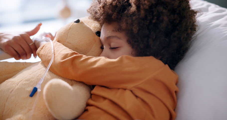 Boy, sleeping and teddy bear in hospital on bed for health, healthcare and medical support. Male child, nap and stuffed animal in clinic for wellness, cancer and medicine with chemotherapy in iv drip