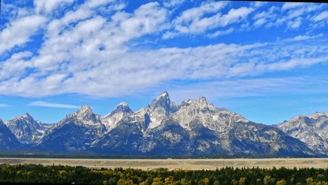 Timelapse of high stratus clouds over Grand Tetons National Park, Wyoming. Camera stationary. Adlı Stok Video
