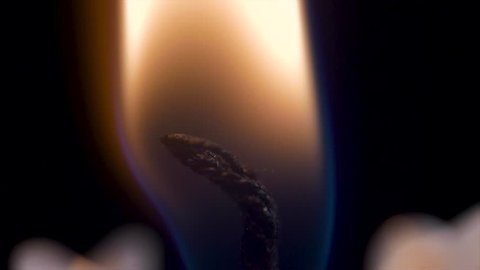 Candle flame closeup over black - Christmas. Candle is lit on a black background closeup. Brightly burning candle macro Video stock